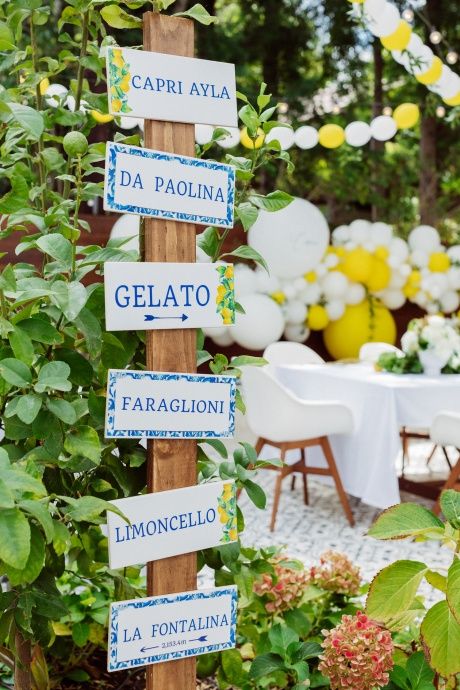 there are many signs on the wooden pole in the garden that read, gelato, limoonicelno and la fontainena