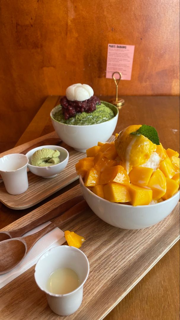 there is a bowl of fruit and two bowls of yogurt on the table