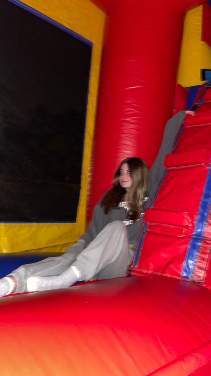 a woman sitting on top of a bouncy castle