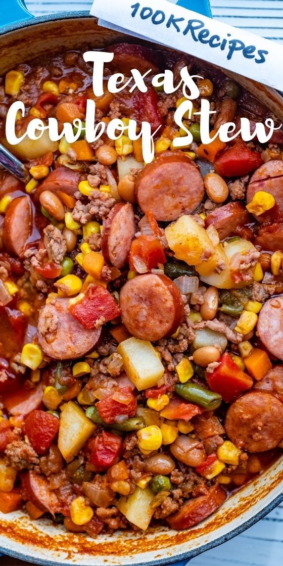 a large pot filled with beans, corn and sausage next to a blue striped table cloth