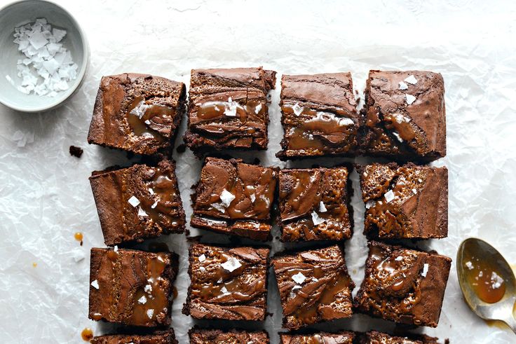 chocolate brownies with sea salt and spoons on the table next to them, ready to be eaten