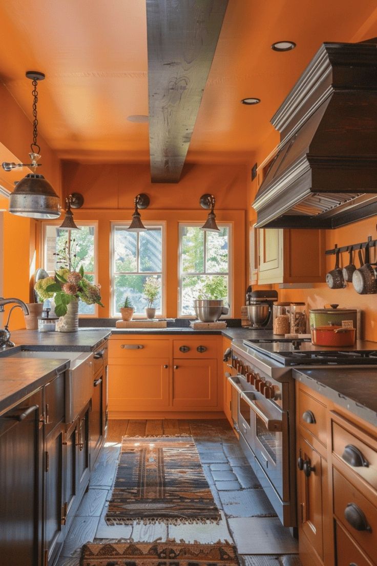 a kitchen with orange walls and flooring next to a stove top oven under two hanging lights