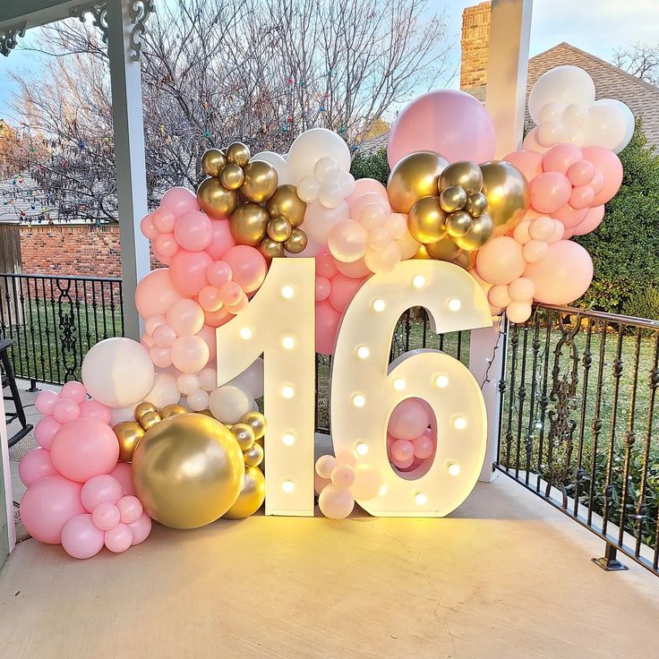 a large number with balloons and lights on the front porch for a birthday or anniversary celebration