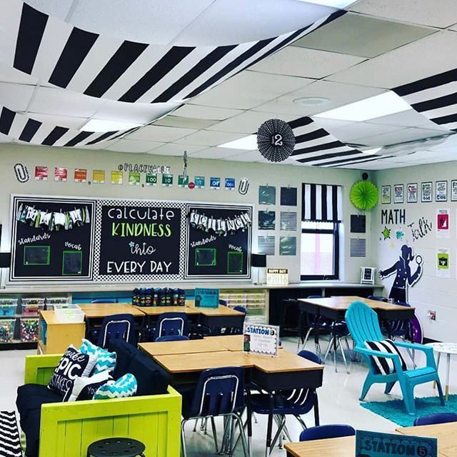 a classroom filled with lots of desks covered in black and white striped wallpaper