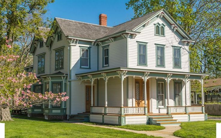 an old house with white siding and green trim