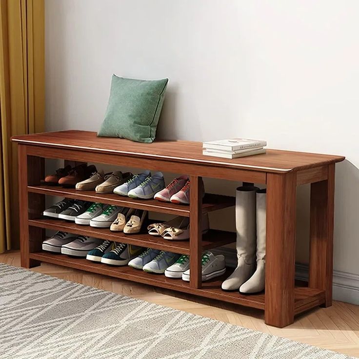 a wooden shoe rack filled with pairs of shoes on top of a rug next to a window