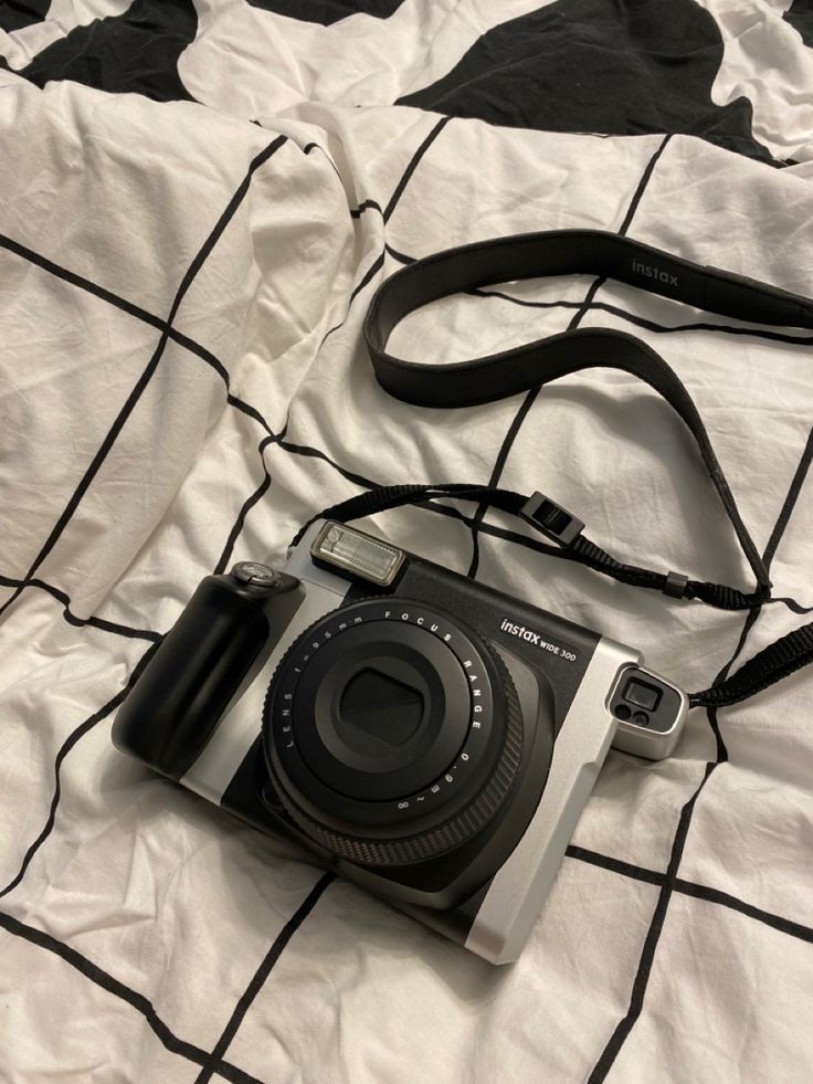 a camera sitting on top of a white and black blanket