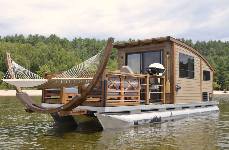 a house boat with a hammock on the deck