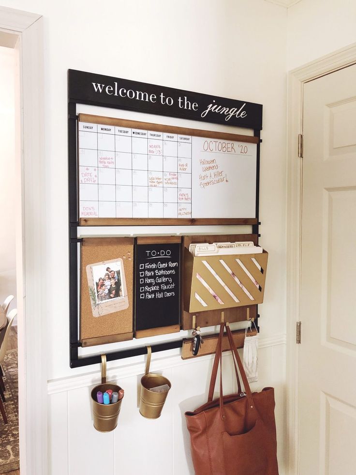 a wall mounted bulletin board next to a purse and other items on the door way