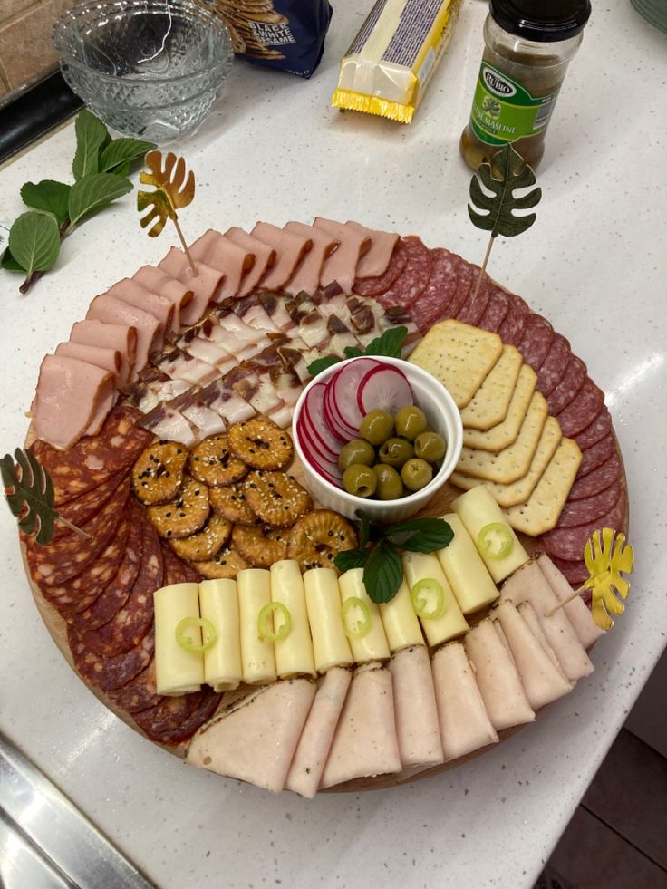 a platter filled with meats, cheese and crackers