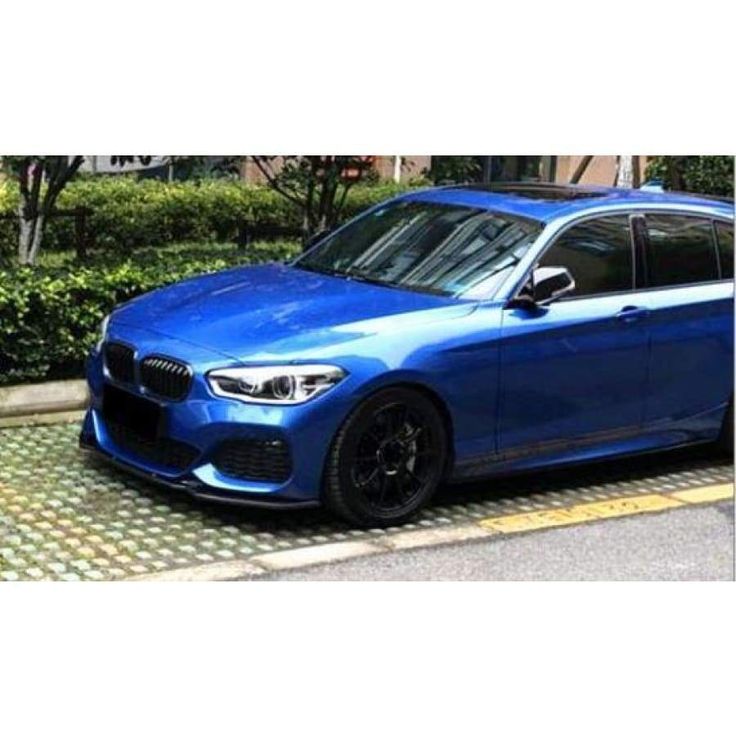 a blue car parked on the side of a road next to bushes and shrubbery