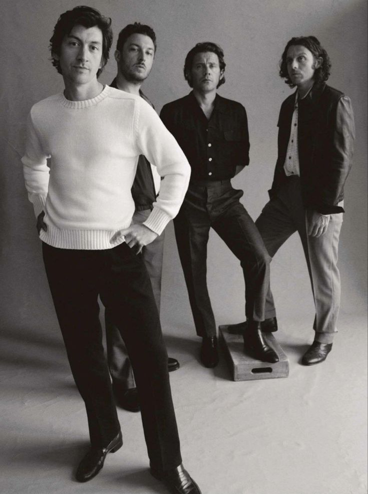 four men standing in front of a white background