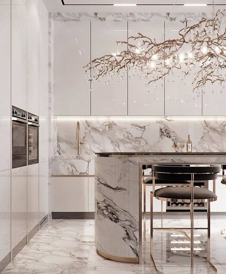 an elegant kitchen with marble counter tops and white walls, along with a chandelier hanging from the ceiling