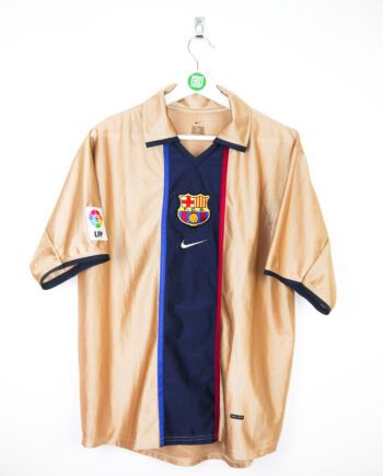 a shirt hanging on a hanger that has a soccer badge on it and the word barcelona written in red, white, and blue