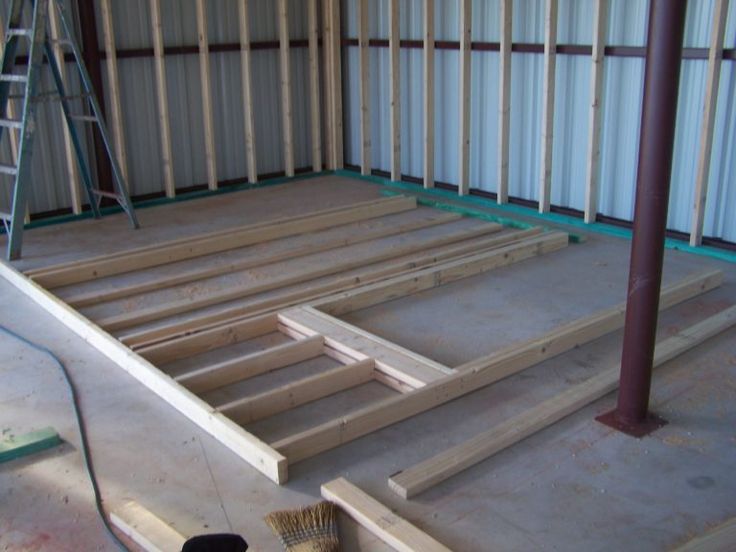 the inside of a building being constructed with wooden boards and scaffolding on the floor