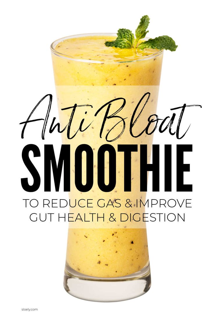 an orange smoothie in a tall glass with mint sprig on top and the words, anti bloat smoothie to reduce gas & improve gut health & digest