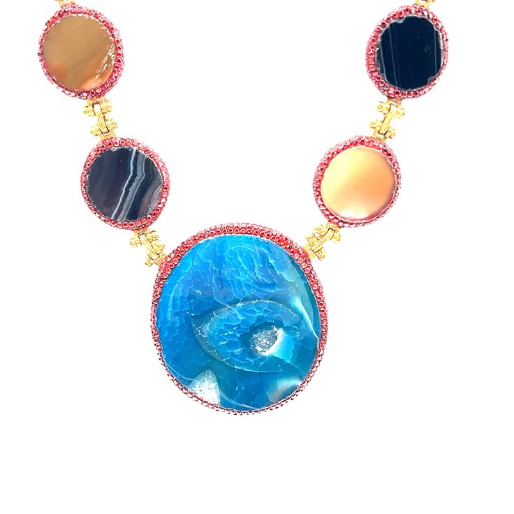 This exquisite necklace showcases a harmonious blend of vibrant gemstones, each radiating its unique charm. The centerpiece is a striking large blue stone, perfectly complemented by an array of smaller multicolored stones, all set in delicate gold settings. Ideal for adding a pop of color and elegance to any outfit. Blue Round Pendant Necklace For Party, Luxury Multicolor Necklace With Gemstone Accents, Luxury Multicolor Gemstone Necklaces, Luxury Multicolor Necklaces With Gemstone Accents, Fusion Multi-stone Round Necklace, Luxury Multicolor Natural Gemstones, Multicolor Multi-stone Oval Necklaces, Multicolor Multi-stone Oval Necklace, Multicolor Oval Multi-stone Necklace