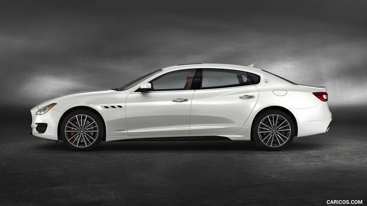 a white masera parked in front of a dark background