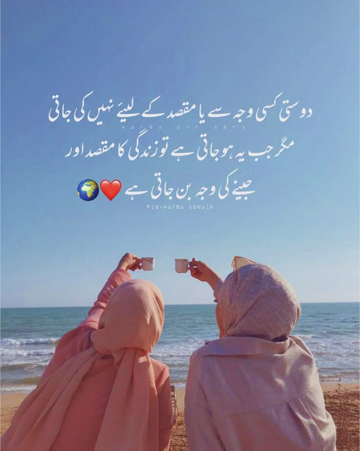 two women are sitting on the beach and looking at the ocean with their backs to each other