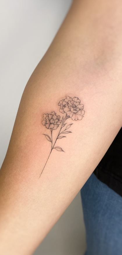 a woman's arm with a small flower tattoo on the left side of her arm