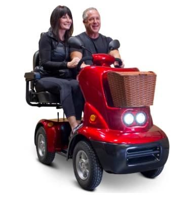 a man and woman sitting on top of a red motorized scooter in front of a white background