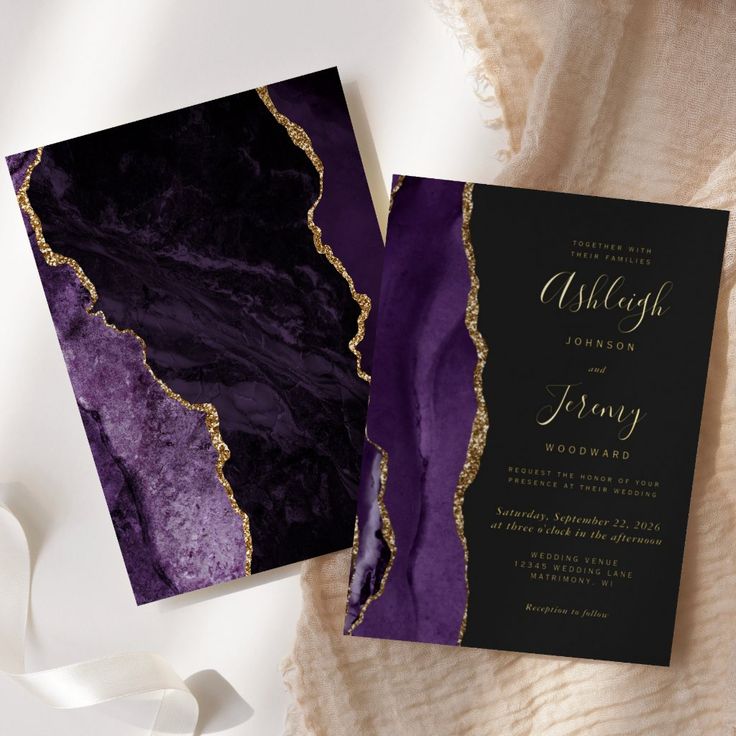 a purple and black wedding card with gold foil on the inside is next to a white ribbon