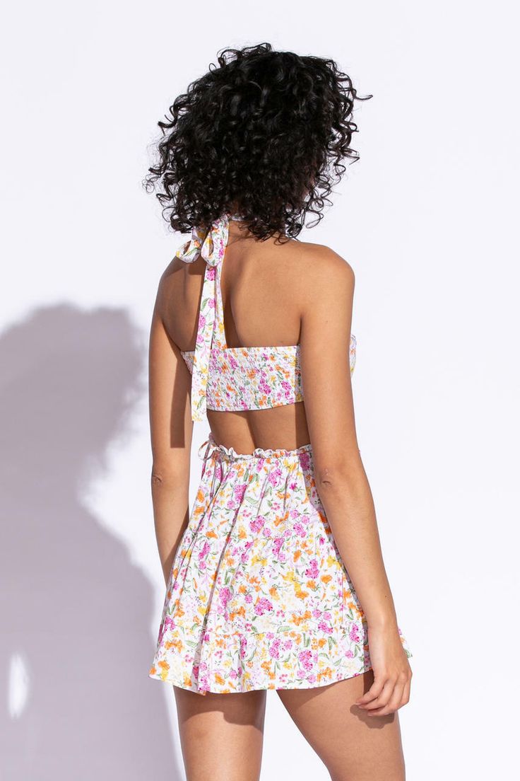 STYLE INFORMATION: Get your Texas boho vibes on in the Sundown Wildflower Floral Print Sundress!. Wildflower floral print, in hues of pink, orange, green, and yellow shapes this cute dress that has a halter V-neckline with tie straps, and a cutout waist.. The open back wraps around to the sides to create a cutout effect above the attached mini skirt. Ruffle trim and side ties decorate the cutout waist. DETAILS & CARE: Rayon/Polyester. Dry Clean. Imported. SHIPPING: We offer free shipping for all Sundress Boho, Halter Sundress, Floral Print Sundress, Skirt Ruffle, Boho Pink, Lemon Print, Halter Mini Dress, Boho Vibe, Pink Orange