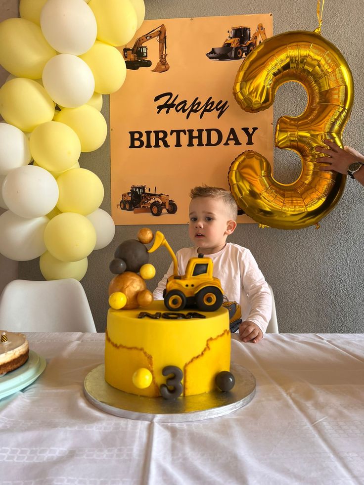 a young boy sitting in front of a birthday cake