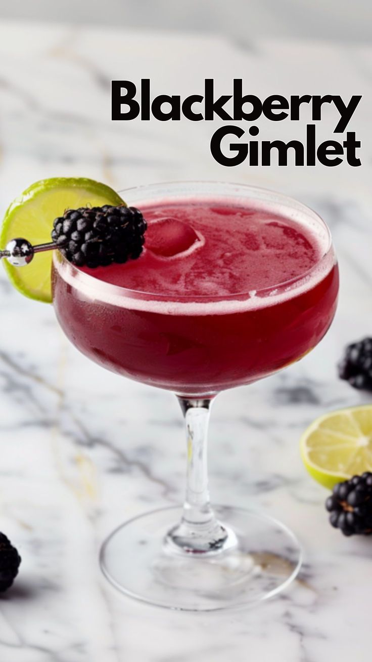 a blackberry and lime cocktail garnished with blackberries on a marble countertop