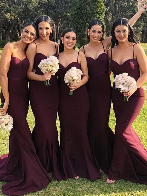 the bridesmaids are all dressed in burgundy dresses and holding bouquets with white flowers