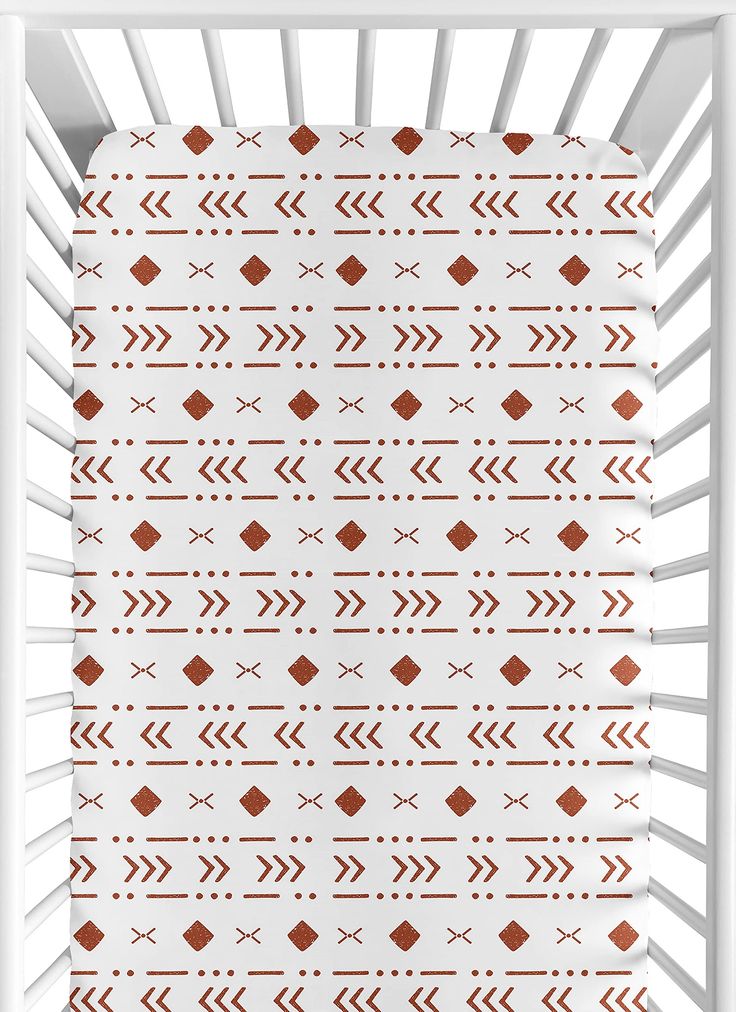 a baby crib with an orange and white pattern on it