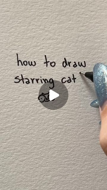 someone is writing how to draw a cat on the wall with glittery blue paint