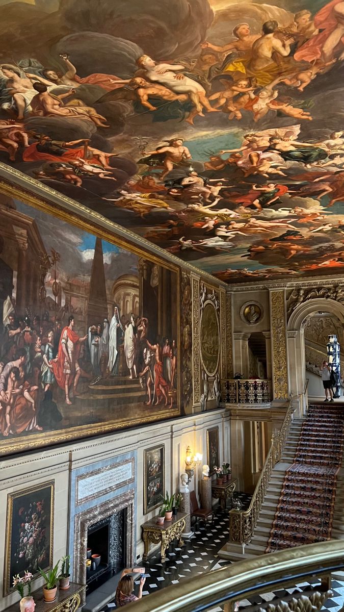 an ornate room with many paintings on the ceiling and stairs leading up to the second floor