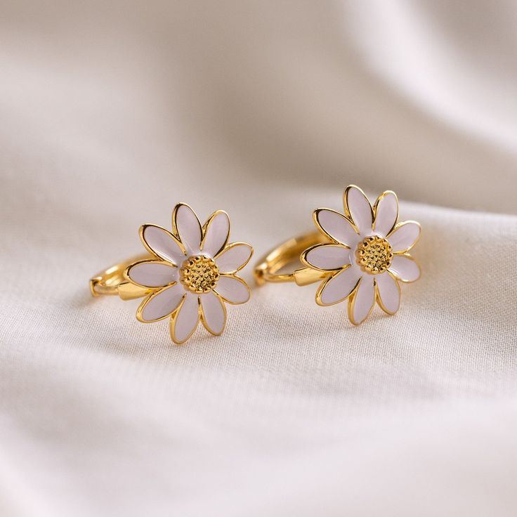 Spring and summer are right around the corner so what better way to bring in the new seasons than with new jewelry! Our Daisy Huggies are bold yet minimalist. With a cute flower design, these earrings are easy to pair with anything for everyday wear. SKU: RR-ER507 Product Details Material: High Quality Solid 925 Sterling Silver Finish: 18K Gold ∙ Sterling Silver Hoop Dimensions: ~10mm Inner Diameter | ~13mm Outer Diameter Featuring Huggie Hoops with a ~12.5x12.5mm Bold Daisy Charm Sold as a Pair Dainty Spring Flower Earrings For Pierced Ears, Elegant Flower Hoop Earrings For Summer, Delicate Flower Earrings For Spring, Gold Flower Charm Earrings For Summer, Delicate Flower Shaped Earrings For Spring, Delicate Flower-shaped Earrings For Spring, White Feminine Everyday Earrings, Feminine White Everyday Earrings, Flower-shaped Jewelry With Matching Earrings For Spring