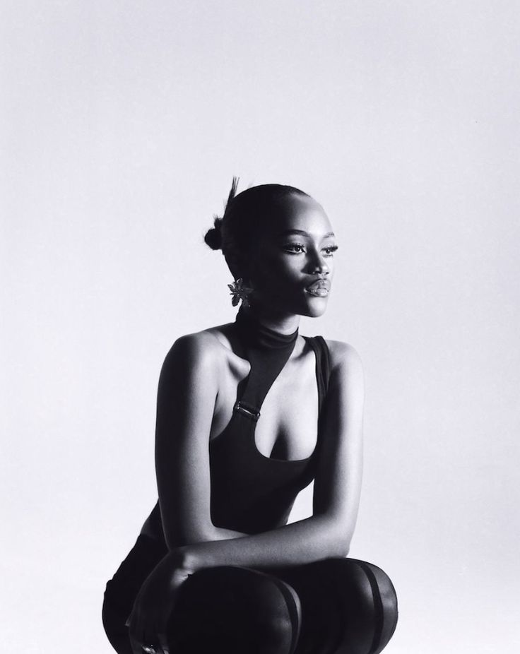 a black and white photo of a woman sitting on the ground