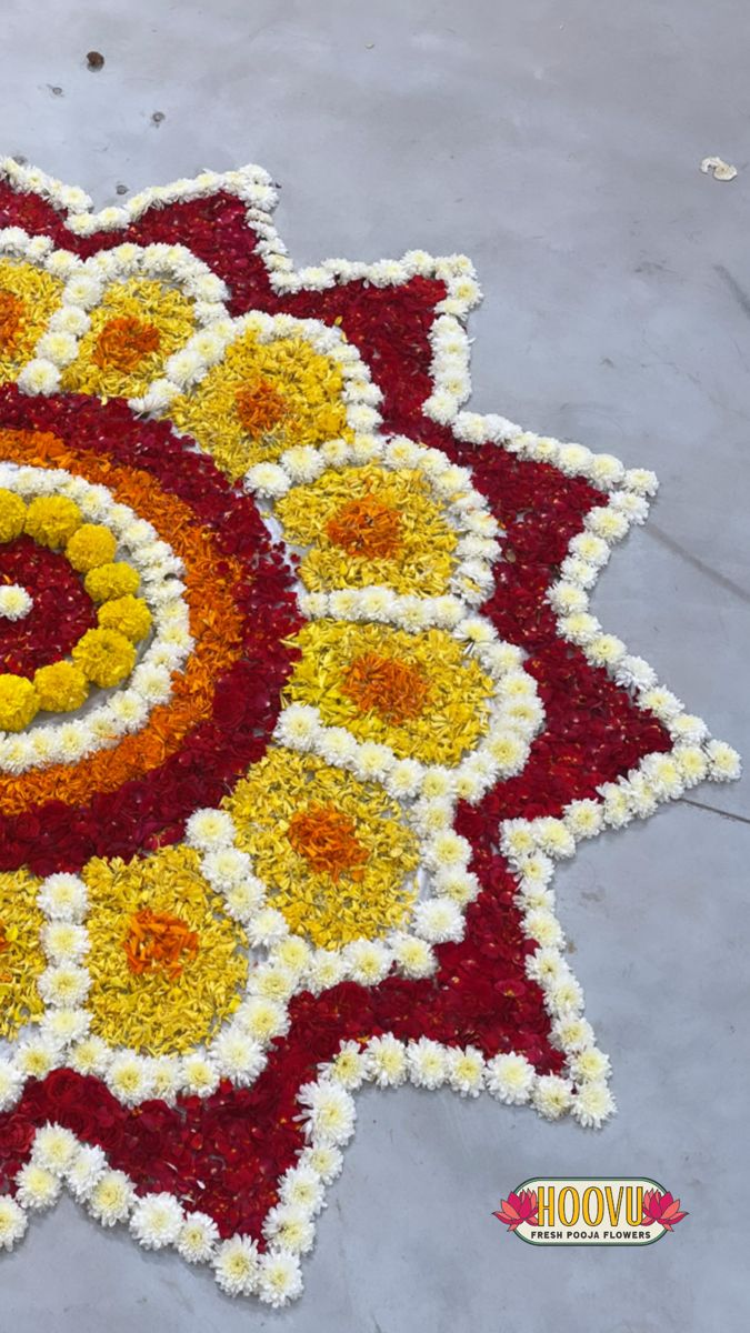 a large flower arrangement on the ground with yellow and red flowers in it's center