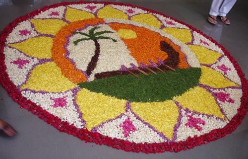 a large flower arrangement is on the floor with people walking around it in the background