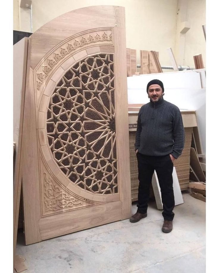 a man standing next to a large wooden door