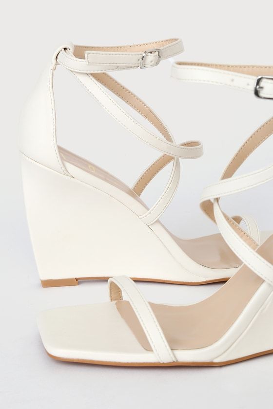 Got some glam plans? You won't be fully dressed until you've got Lulus Luxxa White Strappy Wedge Sandals on your feet! These faux leather sandals have a flat square-toe footbed, a slender toe strap, and matching crisscrossing vamp straps that sit below the adjustable ankle strap. Lightly curved wedge heel finishes the look! 3. 5" wrapped wedge heel. Cushioned insole. Felted rubber sole has nonskid markings. Man made materials. Imported. Lulus | Luxxa White Strappy Wedge Sandal Heels | Size 6.5. Chic Wedge Sandals With Ankle Strap And Cushioned Footbed, Chic Toe Post Platform Wedge Sandals, Chic Toe Post Wedge Sandals For Party, Chic Synthetic Wedge Sandals With Block Heel, Summer Synthetic Wedge Sandals With Square Toe, Summer Wedge Sandals With Square Toe, Chic Wedge Sandals With Buckle Closure, Trendy Square Toe Wedge Sandals For Summer, Trendy Summer Wedge Sandals With Square Toe