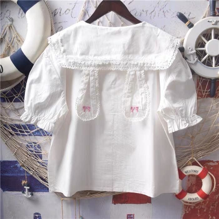 White Bunny Collar Kawaii Lolita Shirt with Pan Collar and Lace Bow Embroidery, available with short sleeves and long sleeves   ONE SIZE Bust: 104cm/41" Length: 56cm/22"     Material: COTTON, Polyester Kawaii Collared Shirt, White Embroidered Top With Collar, Cute White Blouse With Doll Collar, White Blouse With Doll Collar In Cute Style, Casual White Blouse With Doll Collar, Kawaii Cotton Tops, Cute Cotton Blouse With Lace Collar, White Doll Collar Top With Floral Embroidery, White Fitted Harajuku Tops