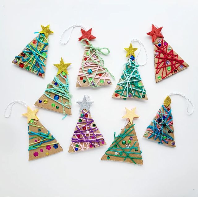 christmas tree ornaments made out of paper and colored pencils are arranged on a white surface