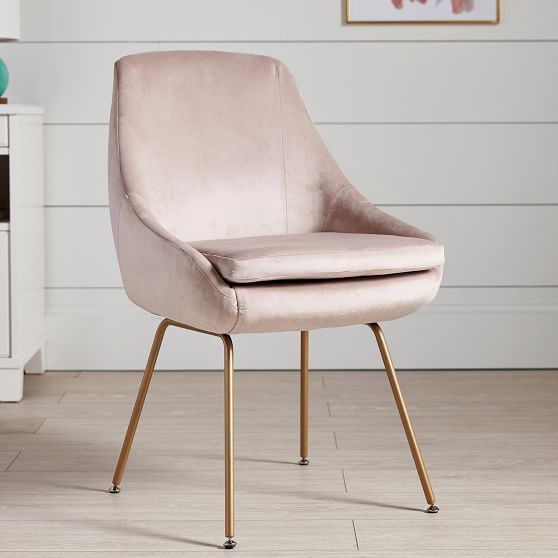 a pink chair sitting on top of a hard wood floor next to a white wall