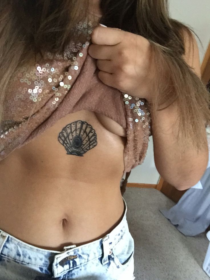 a woman with a tattoo on her stomach is taking a selfie in the mirror