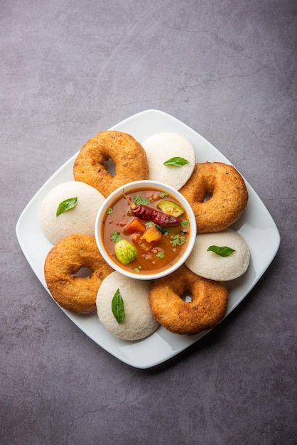 a white plate topped with doughnuts covered in sauce and topping on top of it