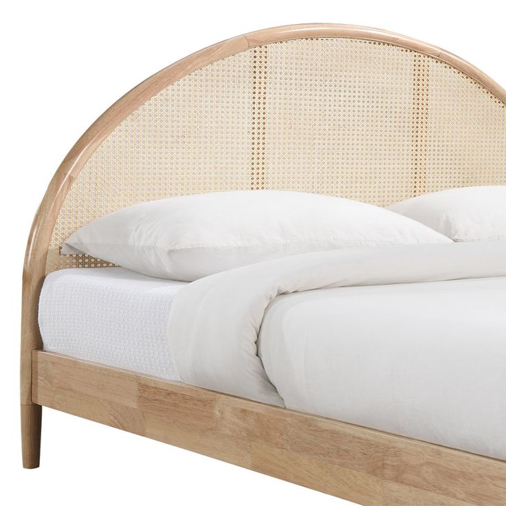 a bed with white sheets and pillows on top of it's headboard,