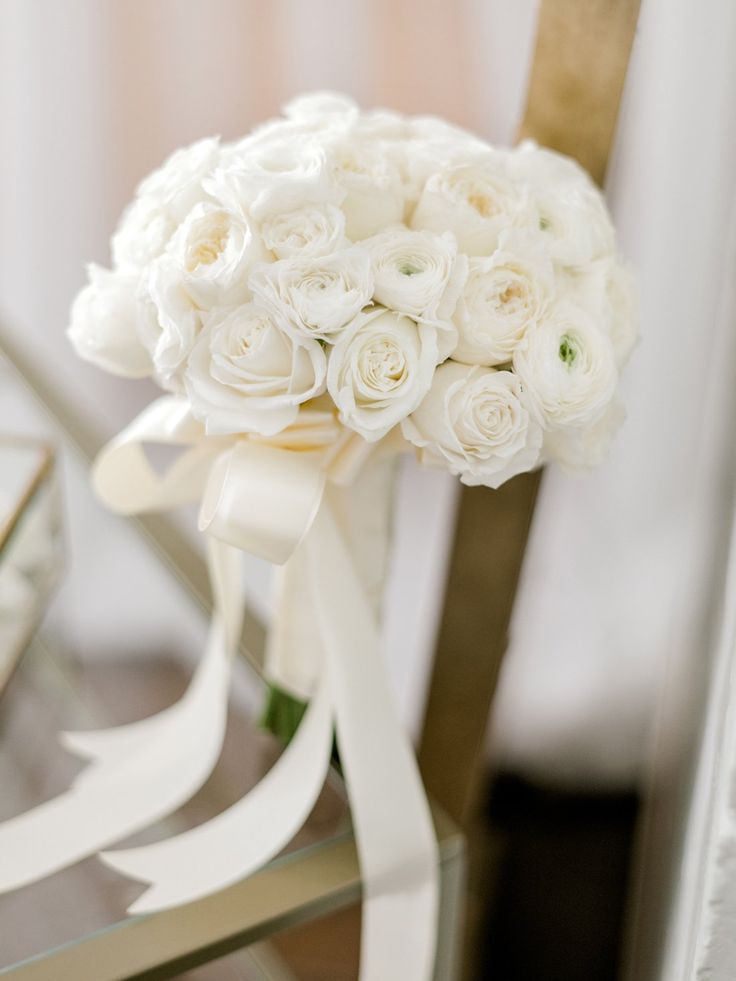 a bouquet of white flowers sitting on top of a chair