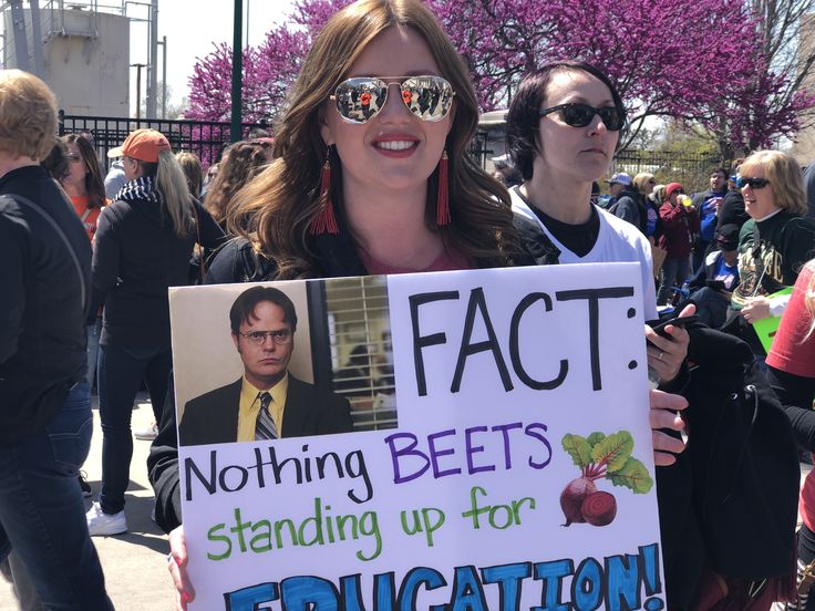 a woman holding a sign that says fact nothing beets standing up for education