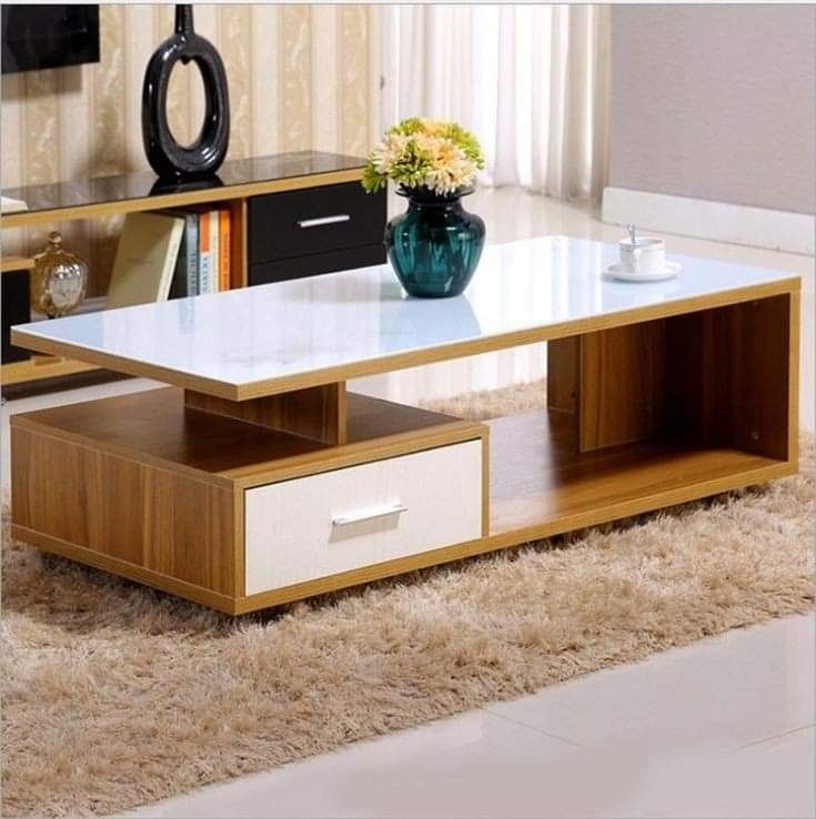 a coffee table with drawers and a vase on top