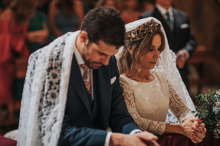 the bride and groom are sitting down at their wedding ceremony, holding each other's hands