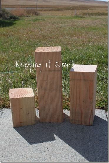 three wooden blocks sitting on top of a cement slab next to grass and a field